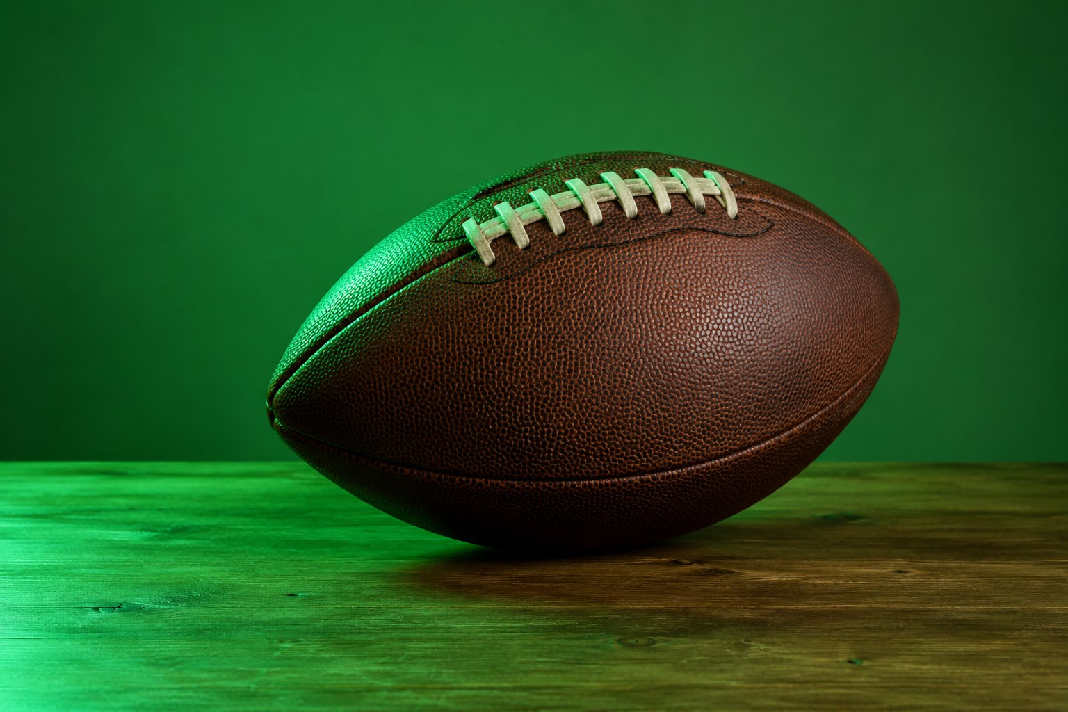 An American football with white laces resting on a table