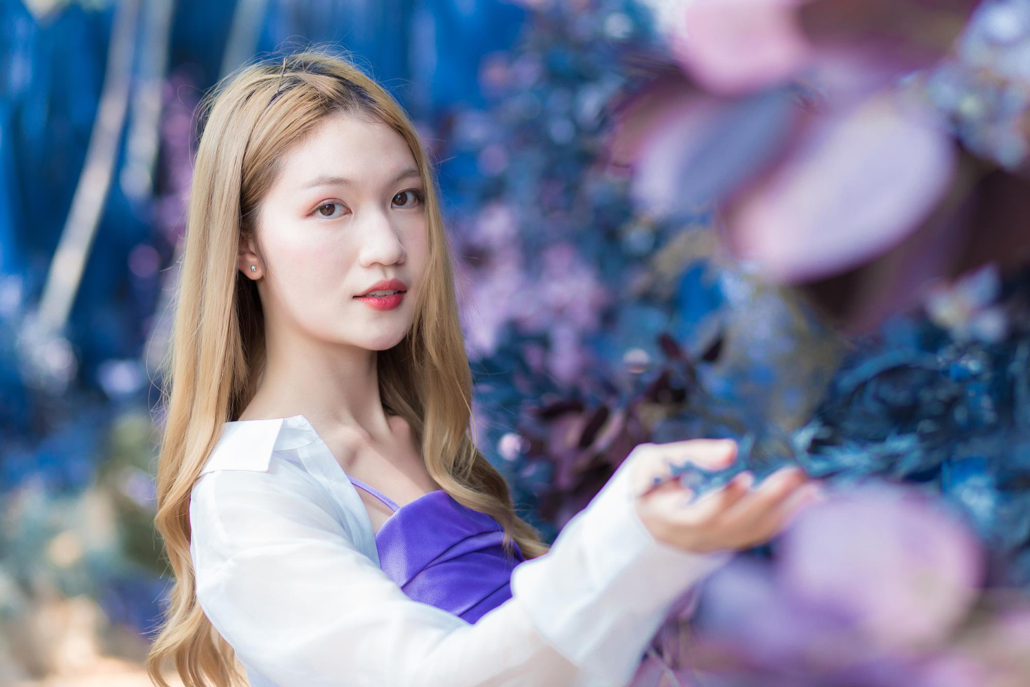 asian beautiful woman who bronze haired wears white shirt purple shirt smiles happily in china