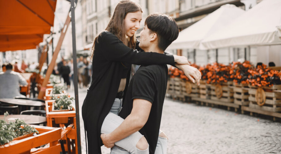asian boy his caucasian girlfriend casual wear standing street couple hugging each other while walking together city