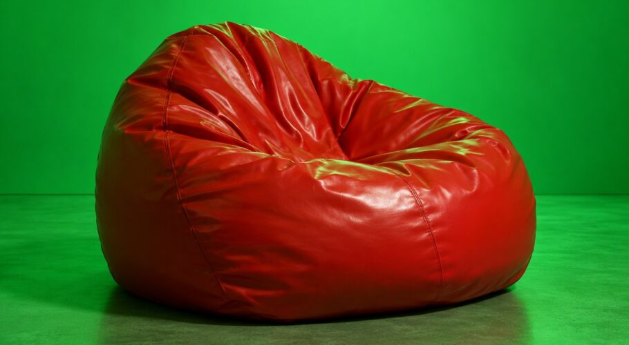 Red vinyl beanbag in a corner in green light