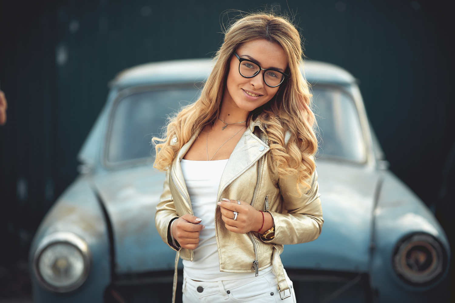 beautiful blonde with long hair white denim shorts stands near old retro car bielka