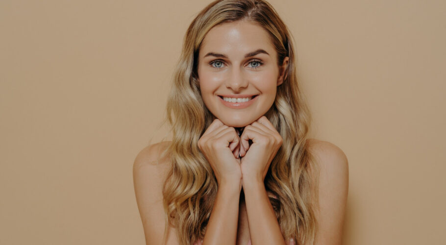 beautiful european female wearing summer light dress holding her hands on her chin