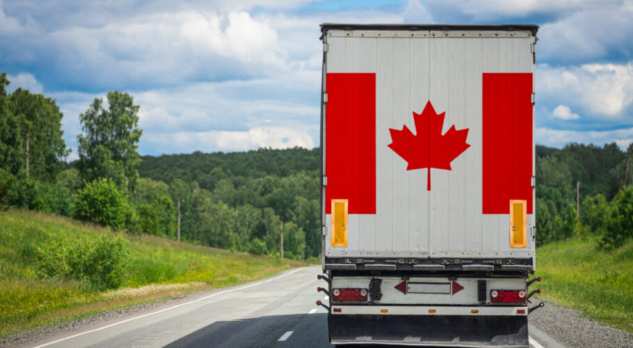 big cargo truck with national flag in canada moving on the highway