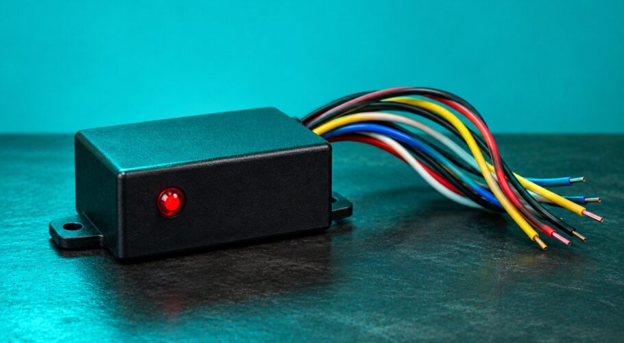 A black turbo timer box with a tangle of wires and one red indicator lamp.