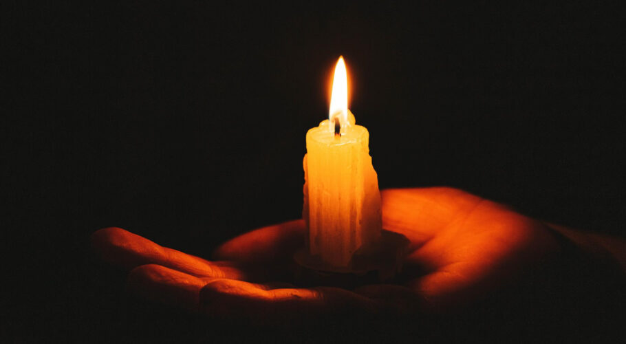 burning candle female hand dark background symbol life love light