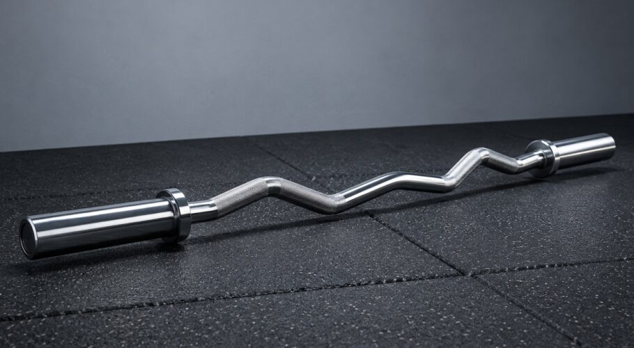 A chrome barbell loaded with black cast iron weight plates on a concrete floor