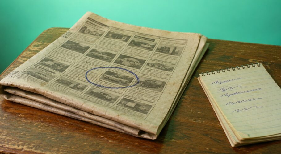 A newspaper page with one ad circled in pen beside a notepad