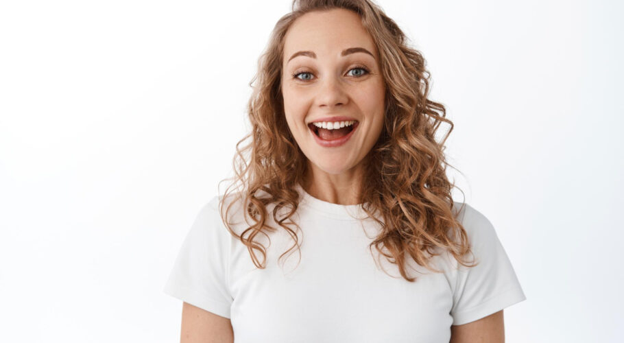 close up excited blond woman smiling pleased looking with joy gratitude standing tshirt