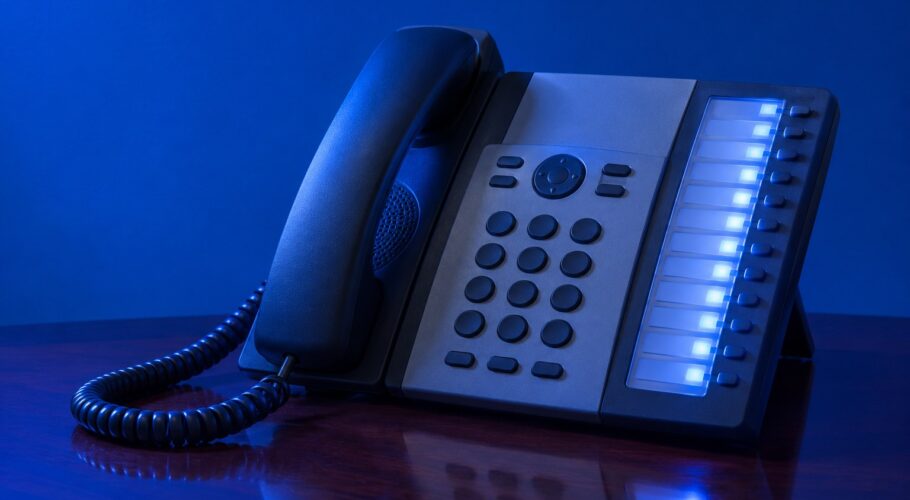 A cream corded telephone with the receiver off the cradle