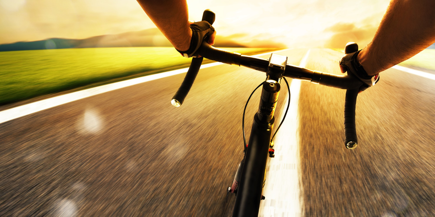 cyclist pedaling fast on a public road in broad daylight