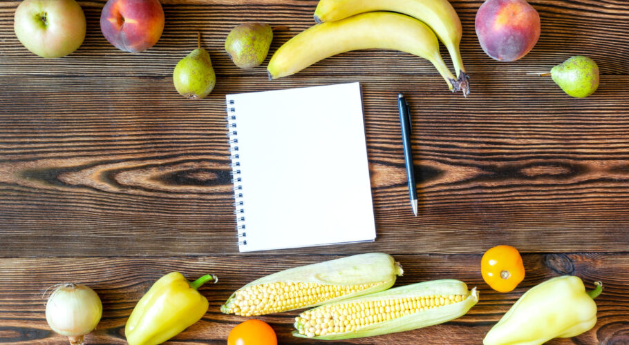 diet fitness vegetarian vegan food dinner with fresh yellow fruits vegetables slimming plan with notebook
