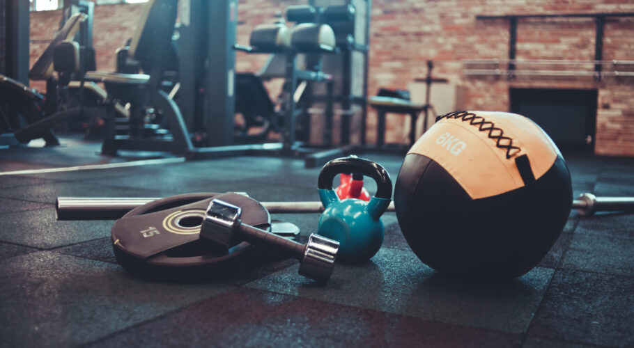 disassembled barbell medicine ball kettlebell dumbbell lying floor gym