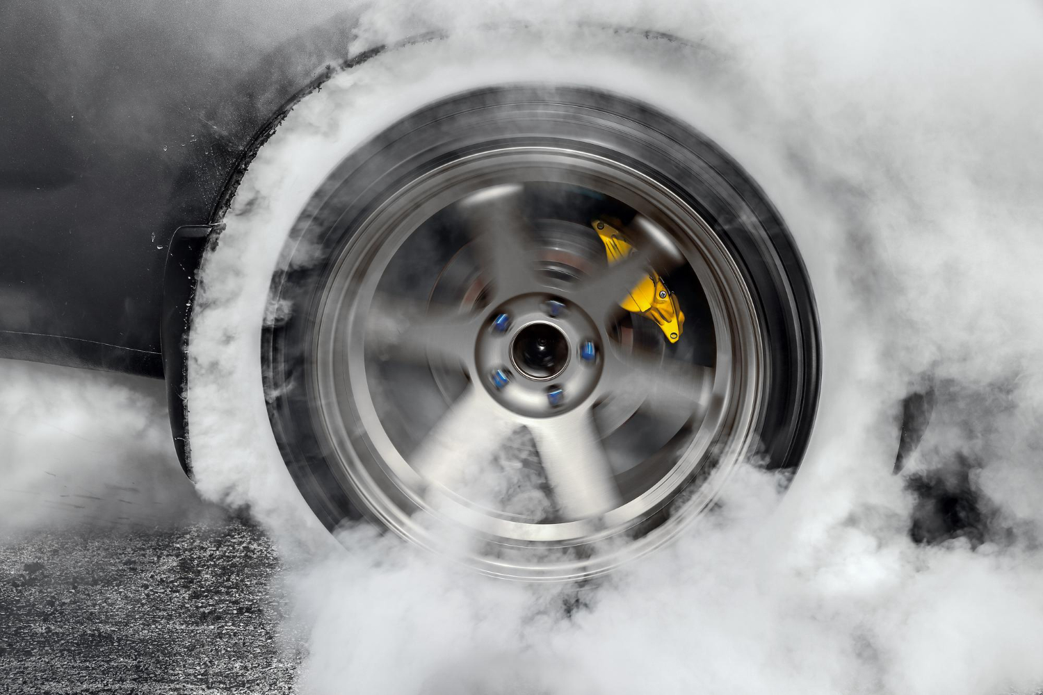 drag racing car burns rubber off its tires preparation race
