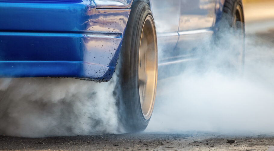 drag racing car burns rubber off its tires preparation race