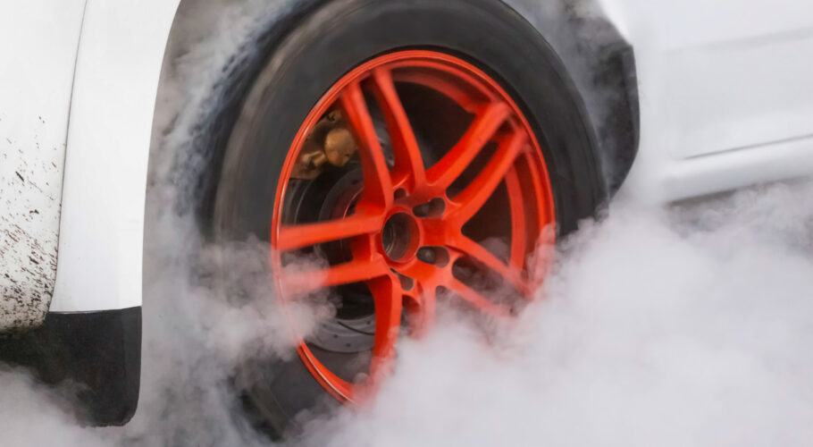 drag racing car burns rubber off its tires preparation race