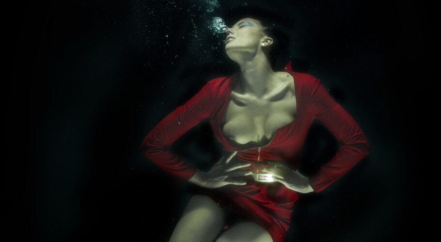 woman in red dress submerged in water fantasy fine art
