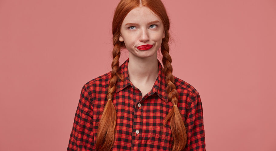 sad negative ginger female kathryn pressing her lips looks aside with confused facial expression
