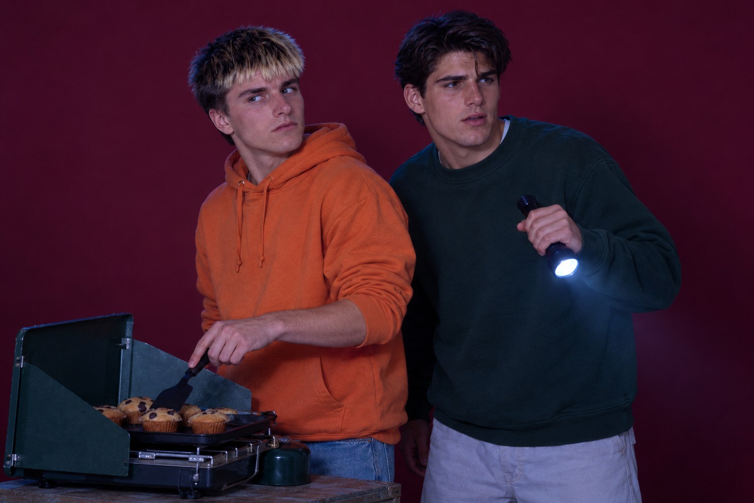 Two young men at a camping hotplate looking wary, studio photograph in the style of 1999 Sydney