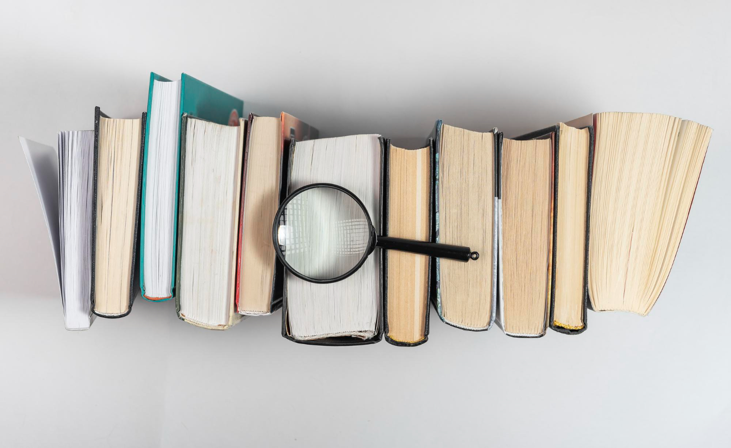 magnifying lens books row concept knowledge studying