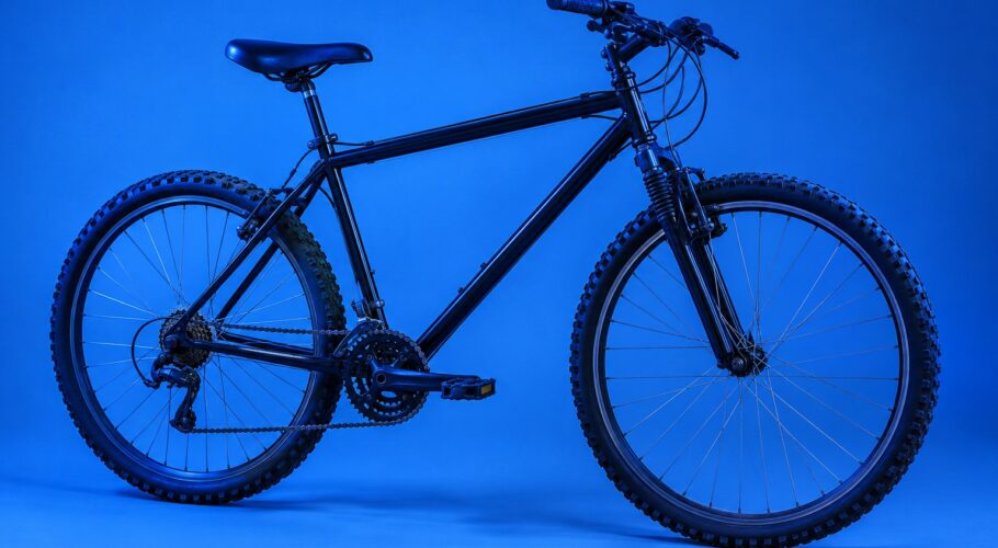 A black mountain bike with chunky tyres standing alone in a studio