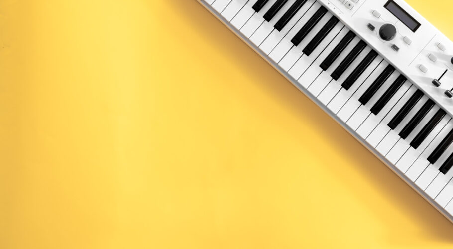 musical background with musical keys yellow flat lay