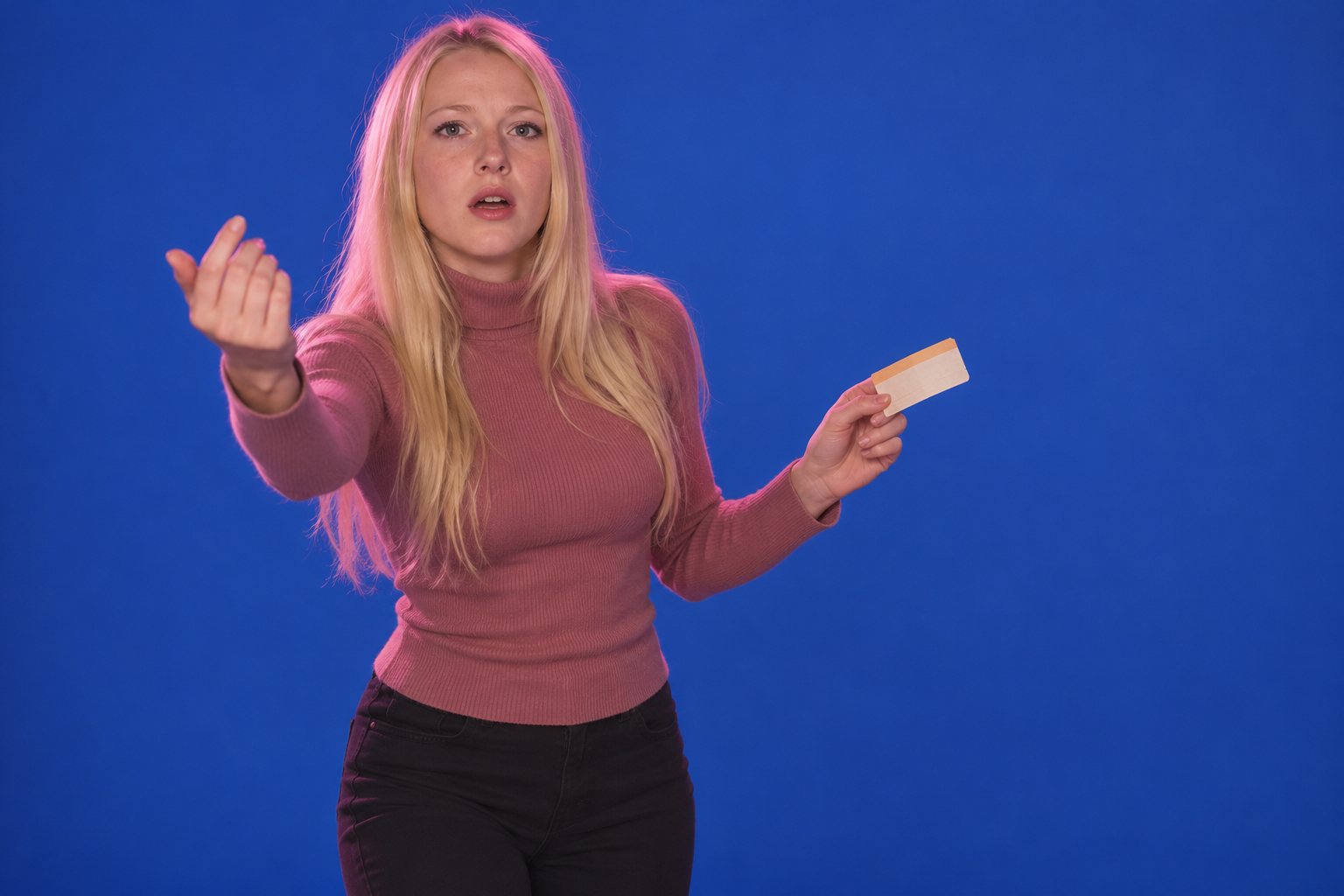 A young woman beckoning with one hand and holding a ticket in the other, studio photograph in the style of 1999 Sydney