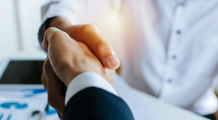 partnership as two business people shake hands after a job interview in a meeting room