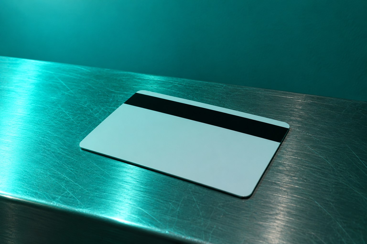 A plain plastic card with a magnetic stripe on a metal bench