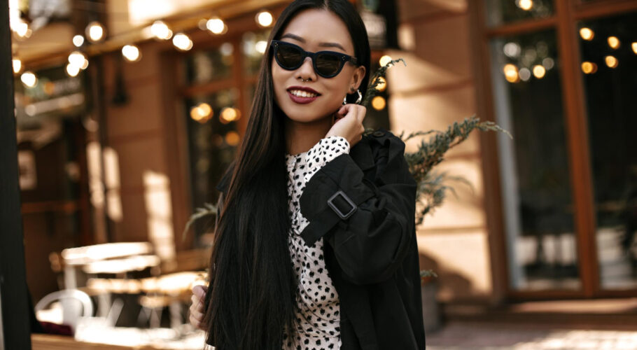 pretty young woman black trench coat polka dot dress asian lady sunglasses poses outside