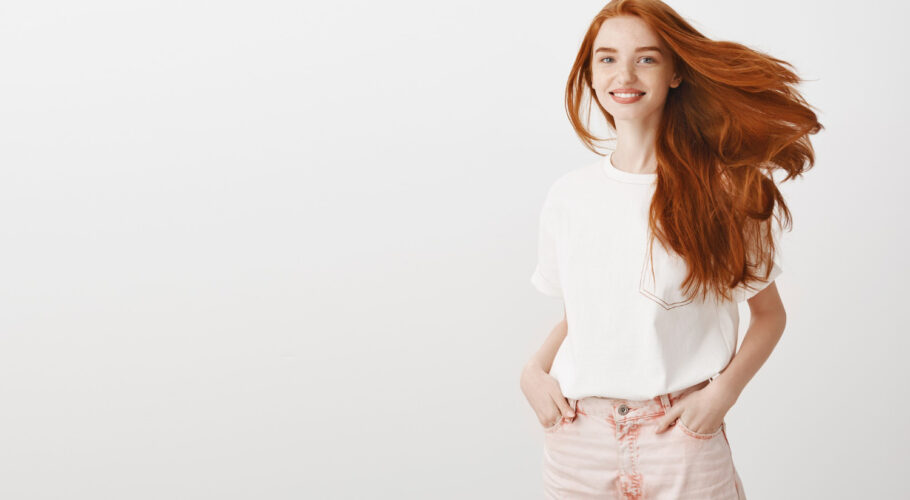 smiling happy attractive redhead girl shaking head enjoying new haircut