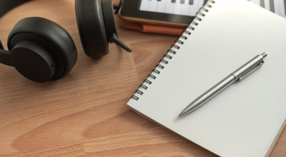 song writing headphones notepad piano and pen on table