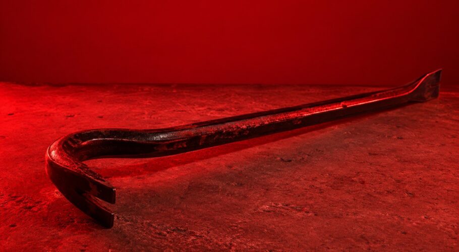 A steel crowbar lying on a concrete slab