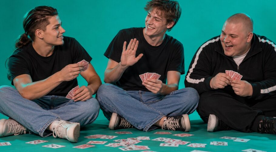 Tony, Keith and Simon on the floor with scattered playing cards, 1999