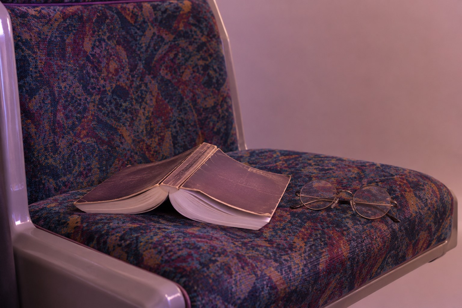 A paperback book resting on a train seat, studio photograph in the style of 1999 Sydney