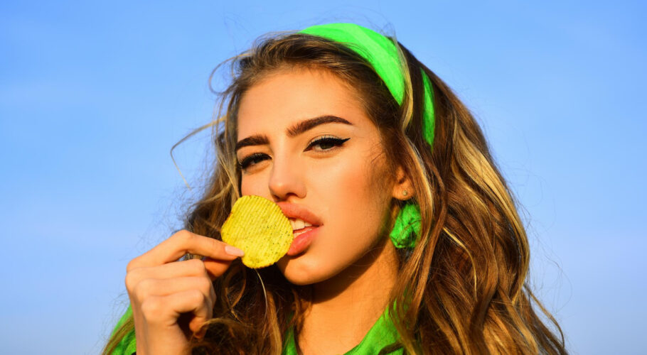 young woman beautiful lips bright makeup holding eating fried potato fries chips posing pretty woman